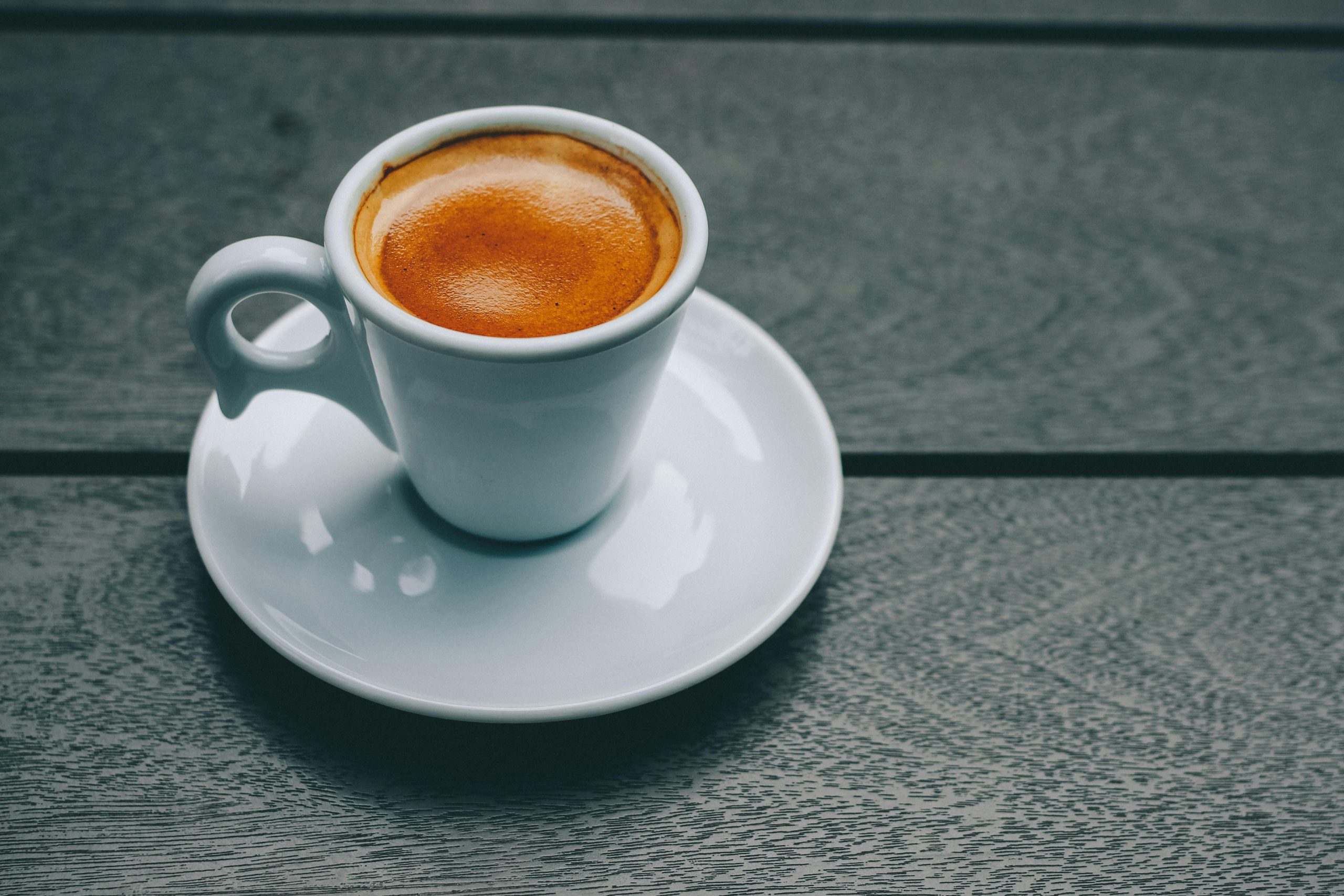 A stylish espresso in a porcelain cup on a wooden table, perfect for coffee lovers.